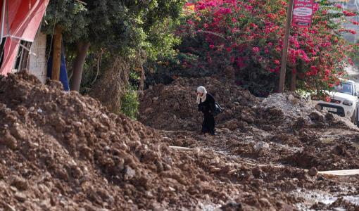 امرأة فلسطينية تمشي على طريق مدمر بعد يوم من اقتحام جيش الاحتلال الإسرائيلي لمخيم جنين للاجئين الفلسطينيين شمال الضفة الغربية المحتلة | المصدر: وكالة الأنباء الفرنسية