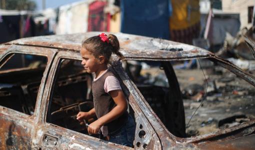 فتاة فلسطينية في سيارة دمرها قصف الاحتلال لساحة مستشفى شهداء الأقصى في دير البلح بقطاع غزة | المصدر: وكالة الأنباء الفرنسية
