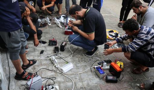 غزيون عند نقطة شحن للهواتف | المصدر: GettyImages