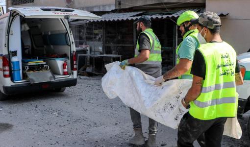 عناصر من الدفاع المدني ينقلون جثة مواطن استشهد في غارة إسرائيلية في قانا | المصدر: وكالة الأنباء الفرنسية