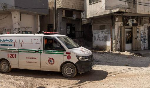 سيارة إسعاف تمر عبر طريق متضرر في مخيم جنين للاجئين في الضفة الغربية المحتلة 9/10/2024 | المصدر: وكالة الأنباء الفرنسية