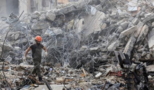 أحد أفراد الدفاع المدني يسير بين أنقاض موقع دمرته غارة إسرائيلية ببيروت | المصدر: رويترز