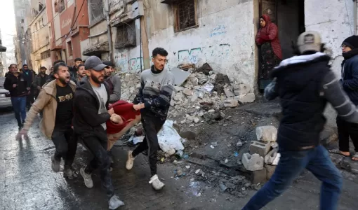 شبان فلسطينيون يحملون جثمان شهيد بعد غارات إسرائيلية على غزة | المصدر: وكالة الأنباء الفرنسية