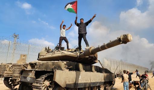 فلسطينيون فوق دبابة للاحتلال يوم طوفان الأقصى فلسطينيون فوق دبابة للاحتلال يوم طوفان الأقصى