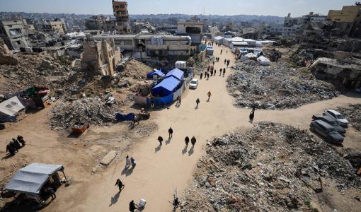 فلسطينيون يسيرون بالقرب من أنقاض المباني في غزة فلسطينيون يسيرون بالقرب من أنقاض المباني في غزة | المصدر: رويترز