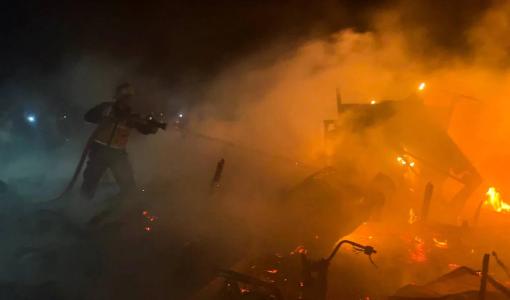 فلسطينيون يحاولون إخماد النيران بعد غارة جوية إسرائيلية على خيام تؤوي نازحين في  مواصي خانيونس جنوب قطاع غزة 17/14/2025 | المصدر: رويترز