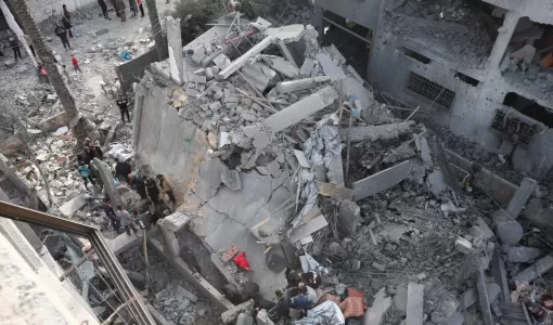 فلسطينيون يتفقدون موقع غارة إسرائيلية على منزل في دير البلح وسط قطاع غزة 7/4/2025 | المصدر: رويترز