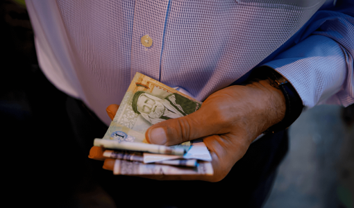 رجل يحمل نقودا أردنية | المصدر: Getty Images
