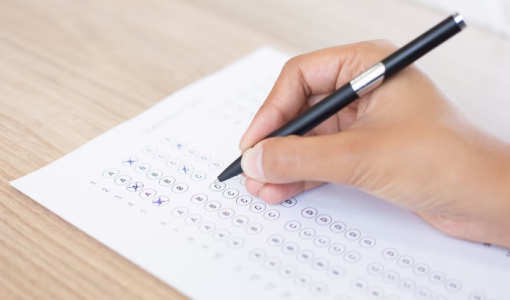 شخص يمسك قلما وورقة إجابات | تعبيرية Freepik