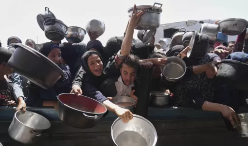 فلسطينيون يحاولون الحصول على الطعام من مطبخ مجتمعي في خانيونس | المصدر: أسوشييتد برس