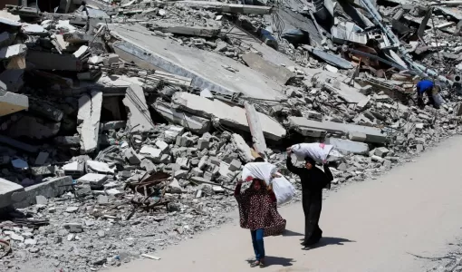 سيدتان تسيران وسط أنقاض المنازل المدمرة بسبب العدوان الإسرائيلي على مدينة غزة 20/5/2025 | المصدر: رويترز