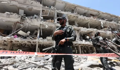 جنود من جيش الاحتلال أمام مبنى مهدم في تل أبيب استهدفته الصواريخ الإيرانية | المصدر: الوكالة الأوروبية للصور الصحفية