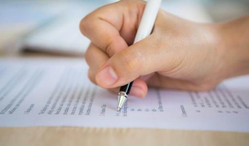 يد وقلم مع ورقة امتحان يد وقلم مع ورقة امتحان | تعبيرية freepik