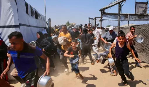 أطفال يهرعون للحصول على وجبة طعام في منطقة مواصي بخانيونس جنوب قطاع غزة 21/7/2025 | المصدر: وكالة الأنباء الفرنسية