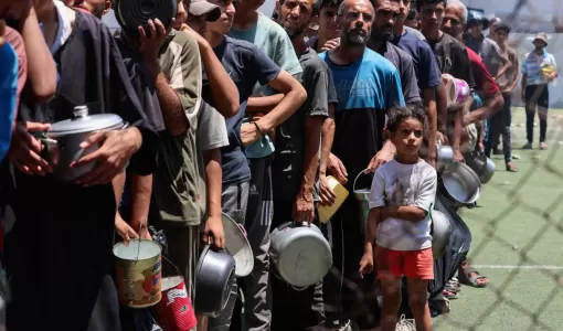 فلسطينيون يقفون بانتظار الحصول على طعام في النصيرات بوسط قطاع غزة | المصدر: رويترز