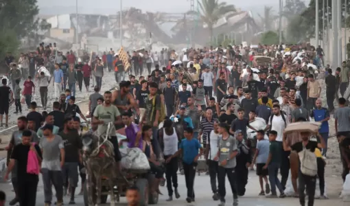 فلسطينيون يسيرون في شارع الرشيد غرب جباليا بعد تسلمهم مساعدات إنسانية من نقطة توزيع مساعدات في شمال قطاع غزة 23/7/2025 | المصدر: وكالة الأنباء الفرنسية