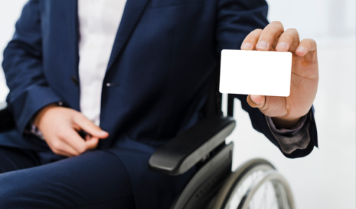 رجل يجلس على كرسي متحرك ويحمل بطاقة | تعبيرية freepik