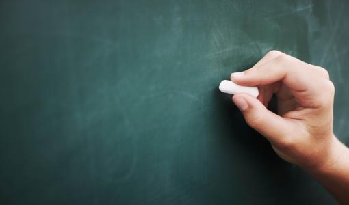 يد تكتب على اللوح | تعبيرية freepik