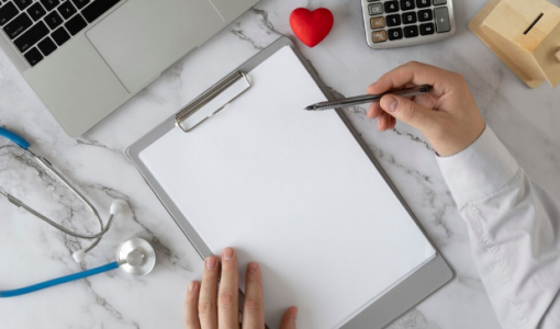 يد تمسك قلما وتظهر سماعة طبية وآلة حاسبة | تعبيرية freepik