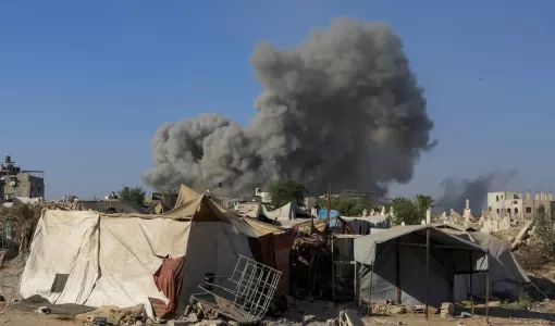 دخان يتصاعد خلف خيام نازحين جراء قصف الاحتلال الإسرائيلي على مدينة غزة | المصدر: رويترز