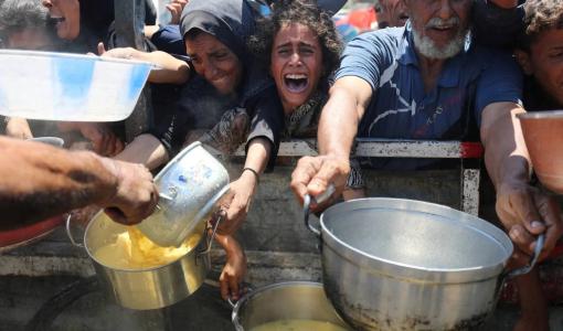 فلسطينيون يحاولون الحصول على الطعام من مطبخ خيري وسط أزمة جوع في مدينة غزة | المصدر: رويترز