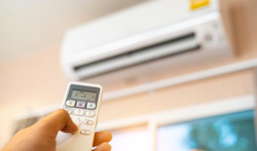 شخص يمسك جهاز التحكم بالمكيف | تعبيرية