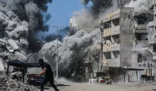 فلسطيني يحاول الاحتماء خلال غارة إسرائيلية على مدينة غزة 27/9/2025 | المصدر: الوكالة الأوروبية للصور الصحفية