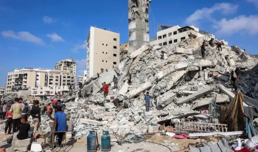 فلسطينيون يفتشون بين أنقاض بمحيط برج مشتهى في مدينة غزة بعد غارة إسرائيلية استهدفته 5/9/2025 | المصدر: وكالة الأنباء الفرنسية