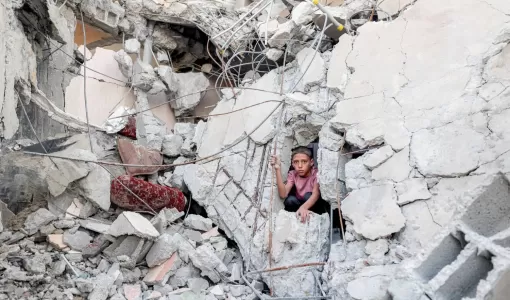 فتى فلسطيني يطل من وسط ركام مبنى دمره قصف الاحتلال الإسرائيلي في مخيم النصيرات للاجئين بوسط قطاع غزة | المصدر: وكالة الأنباء الفرنسية