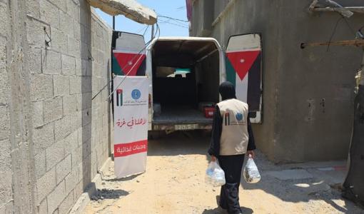 سيدة توزع طرودا ضمن إحدى حملات الهيئة الخيرية الهاشمية