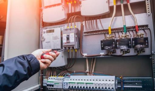 فني كهرباء يستخدم مفكا أثناء العمل داخل لوحة كهربائية | تعبيرية