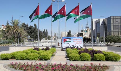 ساحة عامة تتوسطها أعلام الأردن مرفوعة على سوار