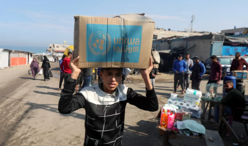 طفل غزي يحمل صندوق مساعدات من الأونروا | أرشيفية رويترز