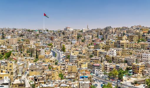 مدينة عمّان يتوسطها علم الأردن