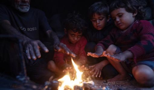 نازحون يتحلقون حولة نار طلبا للدفء في مدينة خانيونس  جنوبي قطاع غزة 27/12/2025 | المصدر: وكالة الأنباء الفرنسية