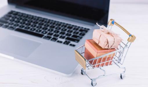 عربة تسوق صغيرة بجانب حاسوب محمول | تعبيرية freepik