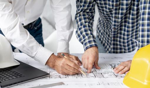 مهندسان يطلعان على مخططات موقع | تعبيرية Freepik