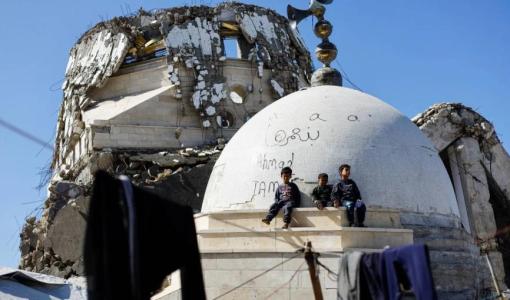 أطفال يجلسون بقرب قبة مسجد دمره جيش الاحتلال خلال حرب الإبادة في مدينة غزة 18/2/2026 | رويترز