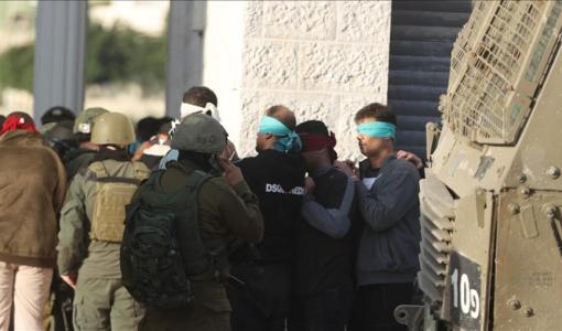 جنود الاحتلال يعصبون أعين فلسطينيين أثناء اعتقالهم بوقت سابق في الضفة الغربية | الأناضول