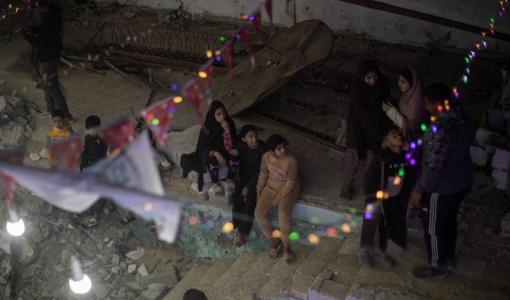 فلسطينيون يعلقون الزينة فوق أنقاض منازلهم المدمرة في خانيونس جنوبي قطاع غزة استعدادا لاستقبال شهر رمضان المبارك | وكالة الأنباء الفرنسية