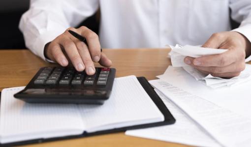 شخص يمسك آلة حاسبة