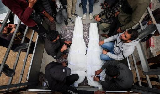 فلسطينيون بجوار جثماني شهيدين إثر غارة إسرائيلية على غزة 26/2/2026 | رويترز