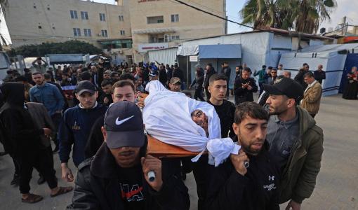 مشيعون يحملون جثمان فلسطيني استشهد إثر غارة إسرائيلية على دير البلح | وكالة الأنباء الفرنسية