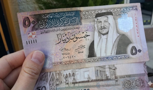 شخص يمسك بعملة أردنية من فئة 50 دينار
