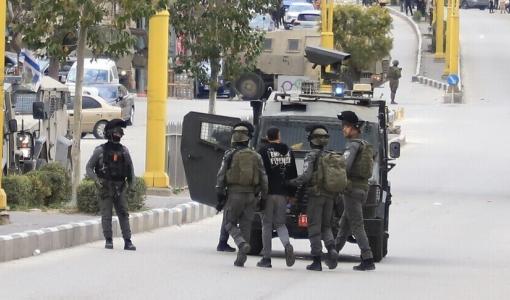 عدد من جنود الاحتلال يقتادون شابا فلسطينيا لاعتقاله | الأناضول