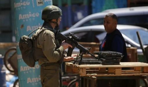 جندي من جيش الاحتلال يعيق تحرك فلسطيني في إحدى بلدات الضفة الغربية | الأناضول