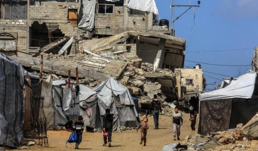 فلسطينيون وسط منازل مدمرة في غزة | العربي الجديد