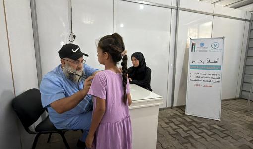 طبيب يجري فحصا لطفلة خلال الأسبوع الطبي المجاني في غزة