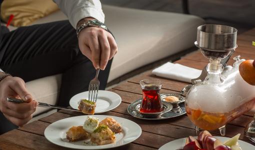 صورة تعبيرية لشخص يتناول حلويات في مطعم