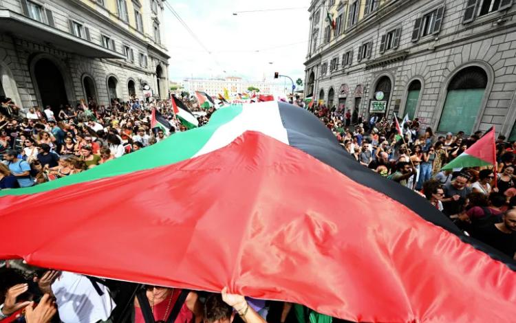 متظاهرون في روما يحملون علما فلسطينيا ضخما خلال إضراب تضامنا مع غزة | وكالة الأنباء الفرنسية